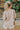 Back view of the To The Moon and Back Top that features a brown knit material, a quilted design, a V neckline, long sleeves, side slits, and a flowy fit.