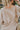 Back view of the To The Moon and Back Top that features a brown knit material, a quilted design, a V neckline, long sleeves, side slits, and a flowy fit.