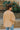 Back view of model wearing the Sloane Corduroy Shacket in Apricot, which features a yellow corduroy material, a collar neckline, a button-up front, a front pocket, and a long cuffed sleeve. 