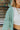 Frontal view of the Sloane Corduroy Shacket that features a jade green corduroy material, a collar neckline, a button-up front, a front pocket, and long cuffed sleeves.