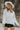 Front view of model wearing the Love Always Top, which has an ivory colored material, a round neck, a 3/4 button-up front, a long sleeve, front lace detail, a babydoll design, and a flowy fit