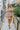 Frontal view of the Tulle Me About It Mini Dress that features a taupe tulle material with a straight neckline, a sleeveless tiered design, a side zipper closure, and a mini length.