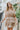 Frontal view of the Tulle Me About It Mini Dress that features a taupe tulle material with a straight neckline, a sleeveless tiered design, a side zipper closure, and a mini length.