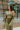 Frontal view of the All Your Life Brami that features a green satin material, a V neckline, a sleeveless design with thin adjustable straps, and a smocked back.