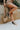 The Elle High-Top Sneaker is a high-top sneaker featuring a nude leather front, a dark grey leather upper, a side star detail, a pink glitter stripe at the heel, an inner side zipper, a lace-up front, and an off-white sole.