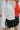 Frontal view of the Don't Get It Twisted Jacket that features a white faux leather material, a collar neck, a button-up front, a monochromatic white checkered print, front fringe detailing, and a cropped fit.