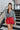 Frontal view of the Take It Back Top that features a washed black denim material, a V neckline, 3/4 sleeves, a ruched front, a keyhole buttoned back, and an elastic bottom hem at the back.