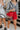 The Clear To Me Purse is a clear purse that can be worn as a crossbody or shoulder purse, featuring a quilted black stitching design, a gold chain with a black leather shoulder strap, and a clasp closure.