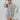 Frontal view of the Maybe My Soulmate Dress that features an ash blue colored chiffon material, a multi-colored floral print, a V neckline, a long sheer sleeve, ruching at the bust, a bottom ruffle tier, a smocked back, and a mini length.