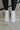 The Rylee High Top Sneaker features a color block leather upper with cream, brown, and pink coloring, a platform sole, a pink heel tab, and a lace-up closure. 