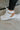 The Rylee High Top Sneaker features a color block leather upper with cream, brown, and pink coloring, a platform sole, a pink heel tab, and a lace-up closure. 