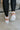 The Rylee High Top Sneaker features a color block leather upper with cream, brown, and pink coloring, a platform sole, a pink heel tab, and a lace-up closure. 