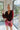 Frontal view of the Take Me Out Bodysuit that features a burgundy velvet material, a surplice neckline with a clasp closure, a long sleeve with a smocked wrist, and a bikini bottom with a snap closure.