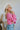 Side view of the Keep On Dreamin' Sweater that features a fuchsia knit material, a knit pattern, a V neckline, a long cuffed sleeve, and a V back with an adjustable tie closure.