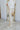Side view of the Keep Shining Pants that features a gold shimmer pleather material, a high-rise waist, a button and zipper front closure, a front pleat down the legs, and a flare leg fit.