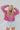 Frontal view of the Stay Cozy Top that features a pink colored thermal material, a round neck, long cuffed sleeves, exposed hems through out, a lettuce edge bottom hem, and a flowy fit.