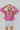 Frontal view of the Stay Cozy Top that features a pink colored thermal material, a round neck, long cuffed sleeves, exposed hems through out, a lettuce edge bottom hem, and a flowy fit.