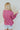 Back view of the Stay Cozy Top that features a pink colored thermal material, a round neck, long cuffed sleeves, exposed hems through out, a lettuce edge bottom hem, and a flowy fit.