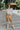 Frontal view of the Picture Perfect Mini Skirt that features a gold colored PU material, a high-rise fit, a back zipper closure, and a mini length.