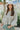 Frontal view of the More Than Words Top that features an ivory colored material, a yellow and green plaid pattern, a round neck, a long sleeve, a babydoll silhouette, an adjustable tie cinched front, and a flowy fit