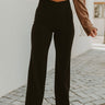 Frontal view of the Let's Chat Pants that features a black colored material, a high-rise waist, a sweetheart cut waist hemline, a seam down the front legs, a wide leg fit, and a back zipper closure.