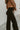 Side view of the Let's Chat Pants that features a black colored material, a high-rise waist, a sweetheart cut waist hemline, a seam down the front legs, a wide leg fit, and a back zipper closure.