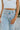 Frontal view of the Signature 8: Crossed Paths Jeans that features a medium wash denim, a front button and zipper closure, crossover waist line, two front pockets, distressing through out, a raw bottom hem, two back pockets, and a wide leg fit.