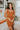 Frontal view of the Neon Moon Mini Dress that features a rust colored knit material, a swirl checkered pattern, a straight neckline, a sleeveless design with thick straps, a tight fit, and a mini length.
