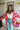 Frontal view of the Simple Times Cardigan that features a pink knit material with an ivory checkered pattern, an open front, and oversized long sleeves.