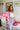 Frontal view of the Simple Times Cardigan that features a pink knit material with an ivory checkered pattern, an open front, and oversized long sleeves.