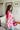 Side view of the Simple Times Cardigan that features a pink knit material with an ivory checkered pattern, an open front, and oversized long sleeves.