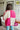 Back view of the Simple Times Cardigan that features a pink knit material with an ivory checkered pattern, an open front, and oversized long sleeves.