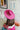 The Road Less Traveled Hat is a wide brim hat, featuring a hot pink fabric, a white aztec pattern belt, and adjustable ties within for different fit.