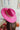 The Road Less Traveled Hat is a wide brim hat, featuring a hot pink fabric, a white aztec pattern belt, and adjustable ties within for different fit.