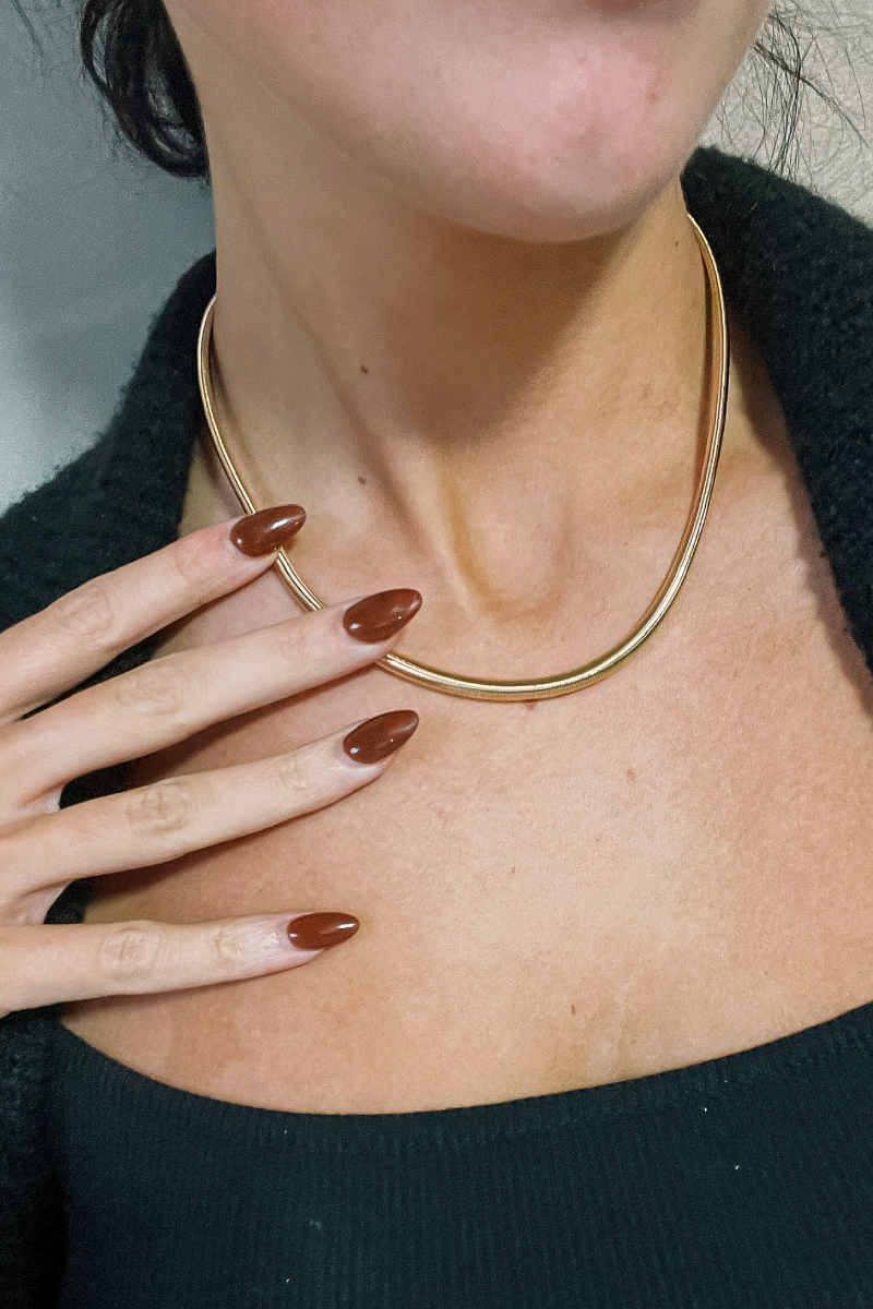 Close up view of model wearing the Emilia Gold Slinky Single Layer Necklace which features single gold slinky layer with adjustable clasp closure.