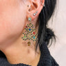 Side view of model wearing the Anastasia Christmas Tree Earrings that feature dangle christmas trees set in gold with multi color stones.