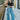 Front view of model wearing the Dakota Cargo Jeans that have blue denim fabric, pockets, a front zipper with a button closure, belt loops and wide legs