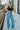 Front view of model wearing the Dakota Cargo Jeans that have blue denim fabric, pockets, a front zipper with a button closure, belt loops and wide legs