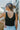 Back  view of model wearing the Best Of The Best Tank Top that has double-layered black knit fabric, a v-neckline and back, and a sleeveless design