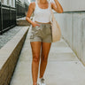 Full body front view of model wearing the Fast Lane Cargo Shorts that have light olive lightweight fabric, cargo pockets and an elastic waistband with drawstring ties.