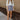 Full body front view of model wearing the Bring It On Skirt that has grey lightweight fabric, two front pockets with drawstring ties, mini length and an elastic waistband with drawstring ties