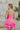 Back view of model wearing the She's Everything Dress that has hot pink fabric, mini length, a three-tiered ruffle skirt, a square neckline, adjustable straps, and a back zipper with a hook closure.