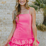 Front view of model wearing the She's Everything Dress that has hot pink fabric, mini length, a three-tiered ruffle skirt, a square neckline, adjustable straps, and a back zipper with a hook closure.