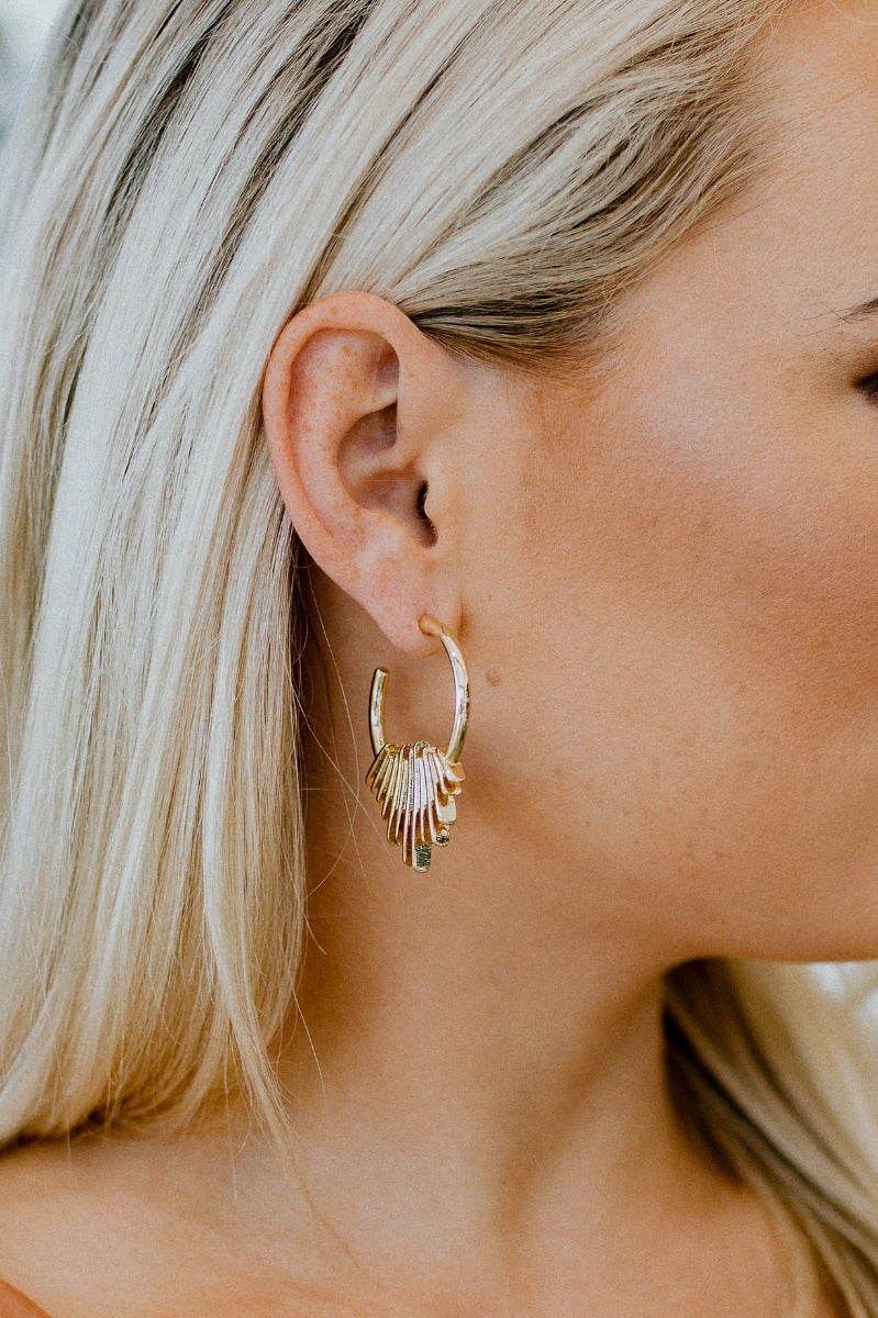 Side view of model wearing the Mixed Emotions Earrings which features open, medium circle with cluster of bars design.