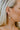 Side view of model wearing the Mixed Emotions Earrings which features open, medium circle with cluster of bars design.