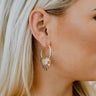 Side view of model wearing the Mixed Emotions Earrings which features open, medium circle with cluster of bars design.