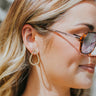 Side view of model wearing the Nothing Is Forever Earrings which features small, teardrop shaped hoops with small gold beads.