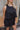 Close up view of model wearing the All Over Again Romper which features black lightweight fabric, shorts lining, tiered ruffle design, round neckline, sleeveless and monochromatic back zipper with hook closure.