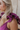 Close up view of model wearing the Moment in Time Jumpsuit which features plum lightweight fabric, plum lining, wide leg pants, criss cross detail at waist, plunge neckline, ruffle straps, corset ties in the back, open back and monochromatic back zipper w