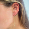 Side view of model wearing the Dress It Up Earrings which features gold chain link with a rectangle and teardrop shape clear stones.